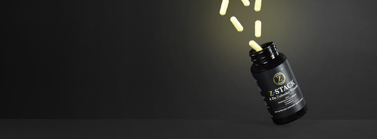 a black bottle of z-stack on a black background with the capsules flying out of the bottle