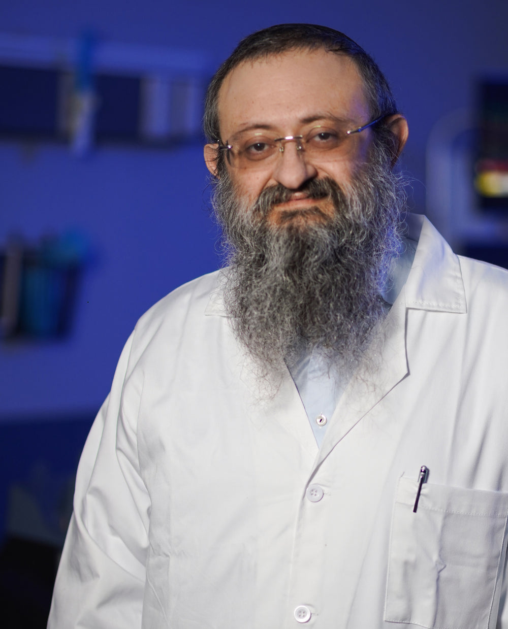 Doctor Zelenko, a man with a beard and glasses wearing a suit against a dark background